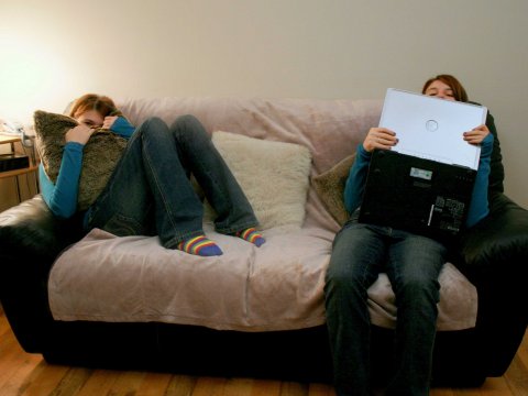 young-people-on-couch-laptops-hiding-home-house-living-room.